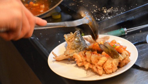 The presentation of the squirrel-shaped mandarin fish is integral to the culinary experience